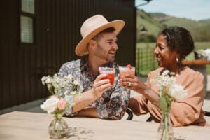 A man and woman sitting at a table with drinks.