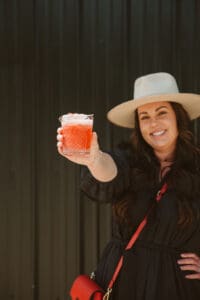 A woman holding up a glass of juice.