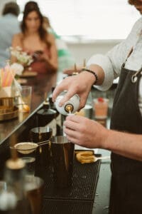 A person is pouring something into a glass.