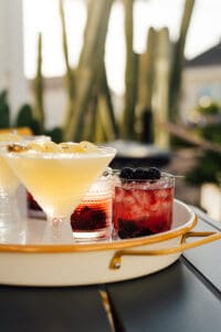 A tray with two different drinks and some berries.