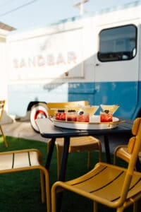 A table with food on it and chairs around.